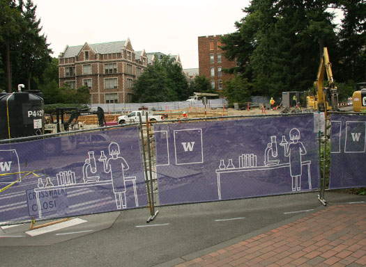 construction fencing with construction activity going on behind it near the hub