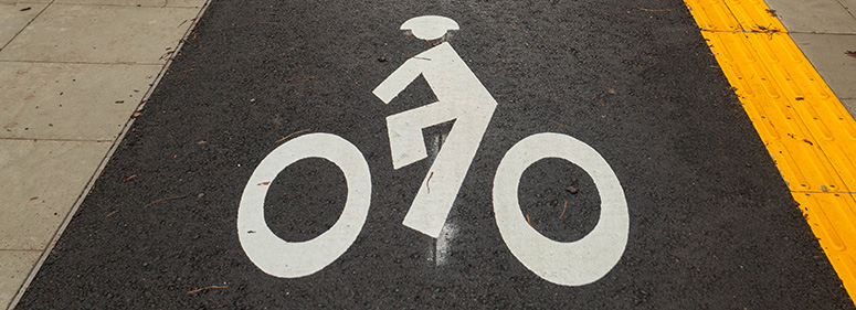 painted white cyclist icon on bike trail