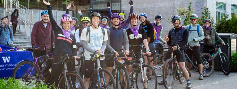 diverse group of fifteen smiling bicyclists standing with their bicycles