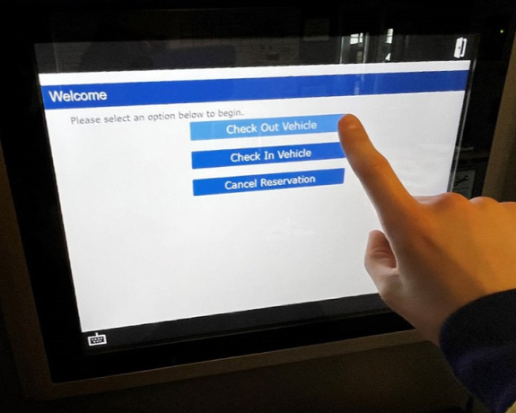 screen shot of kiosk screen with person's finger touching the check out vehicle button