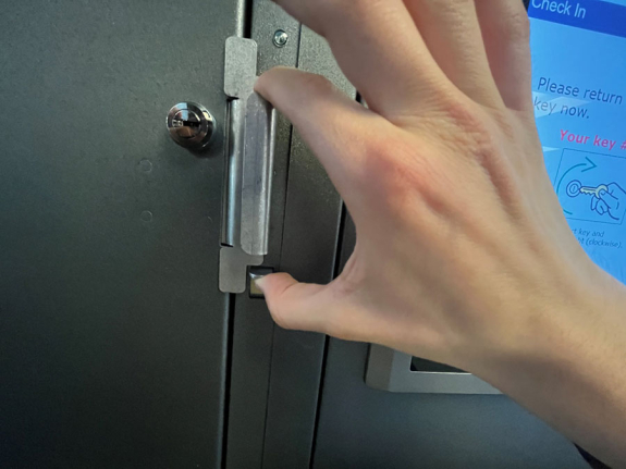 key manager box handle with person's hand squeezing the access latch