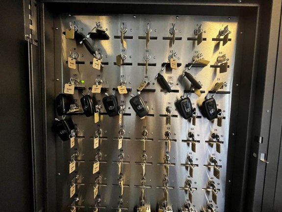 key manager box interior with multiple keys hanging from a grid of numbered slots with an indicator light illuminated green at slot 15