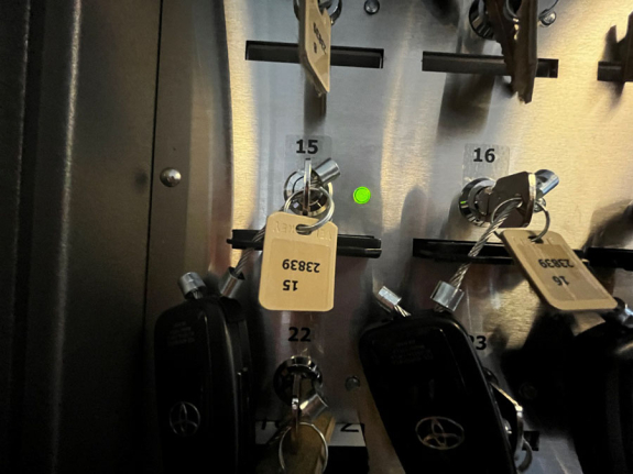 key manager box showing close up of slot 15 with green light illuminated and metal key inserted attached to car key fob