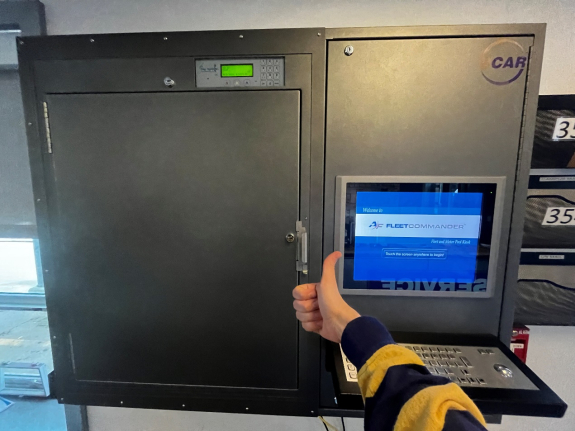 person's hand with a thumbs up in front of closed key manager box and touch screen