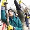 person holding up poles to build structure